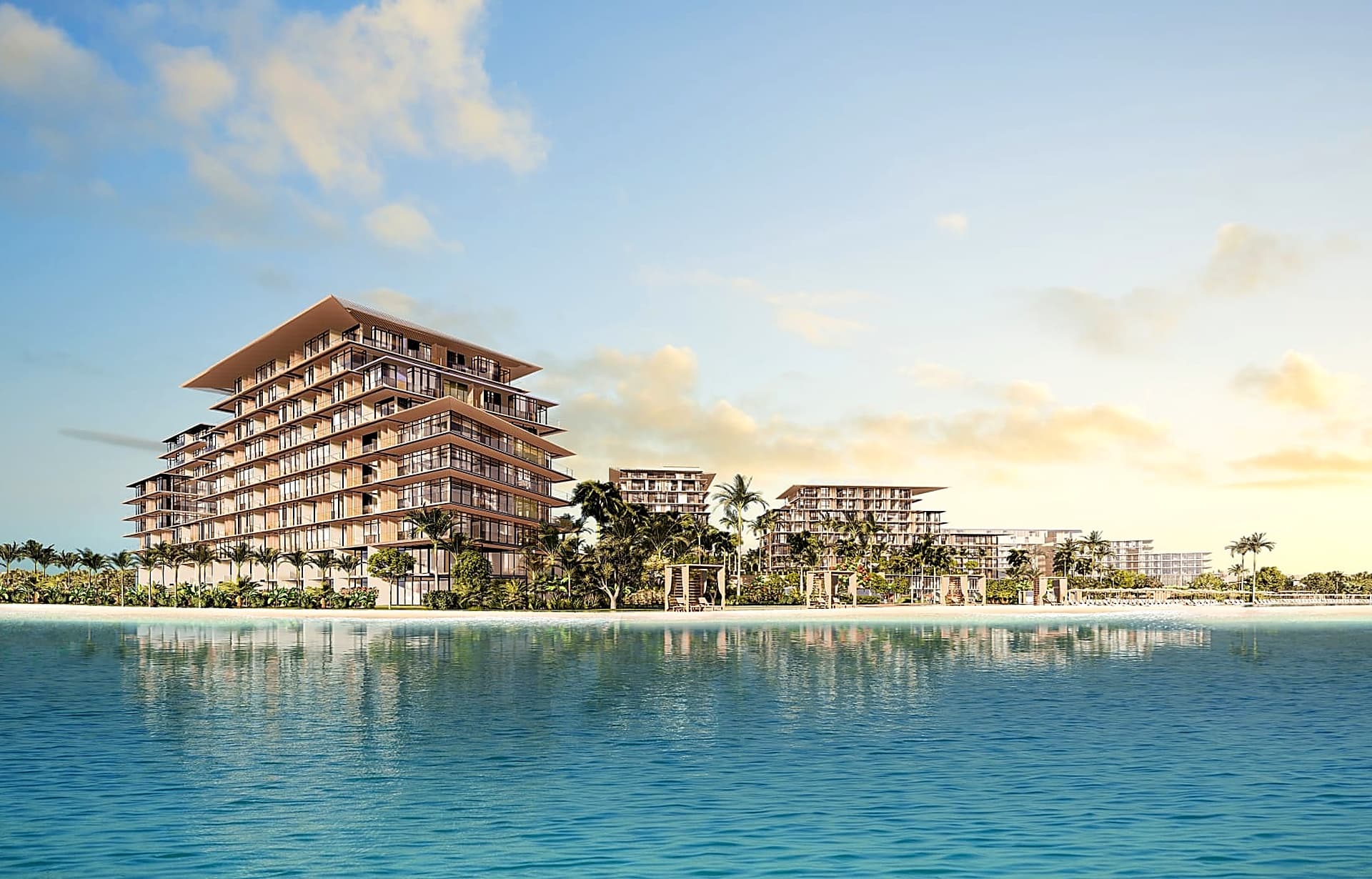 Modern luxury beachfront resort buildings with tiered design overlooking turquoise ocean waters.