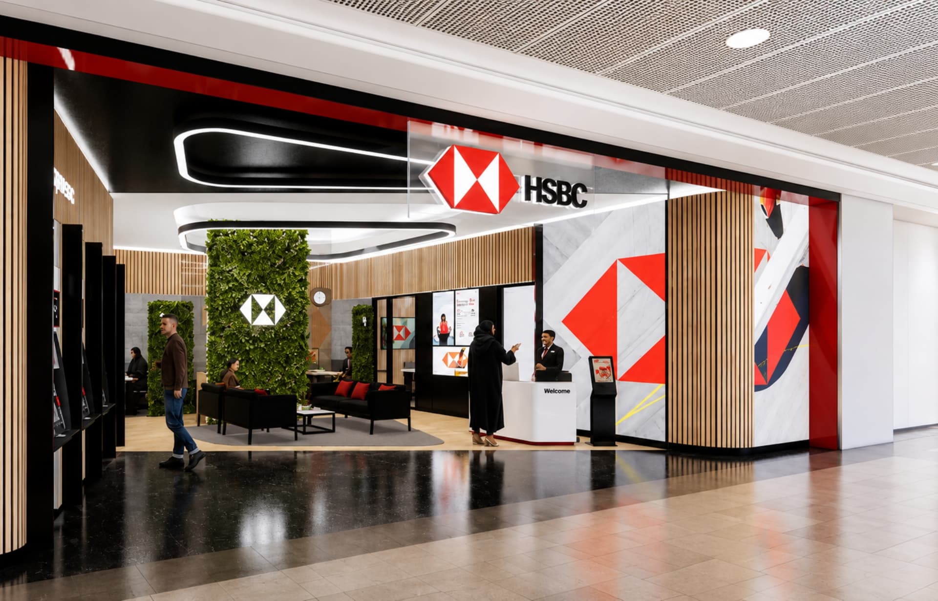Modern HSBC bank branch interior with red geometric logo, wooden accents, and welcome desk.