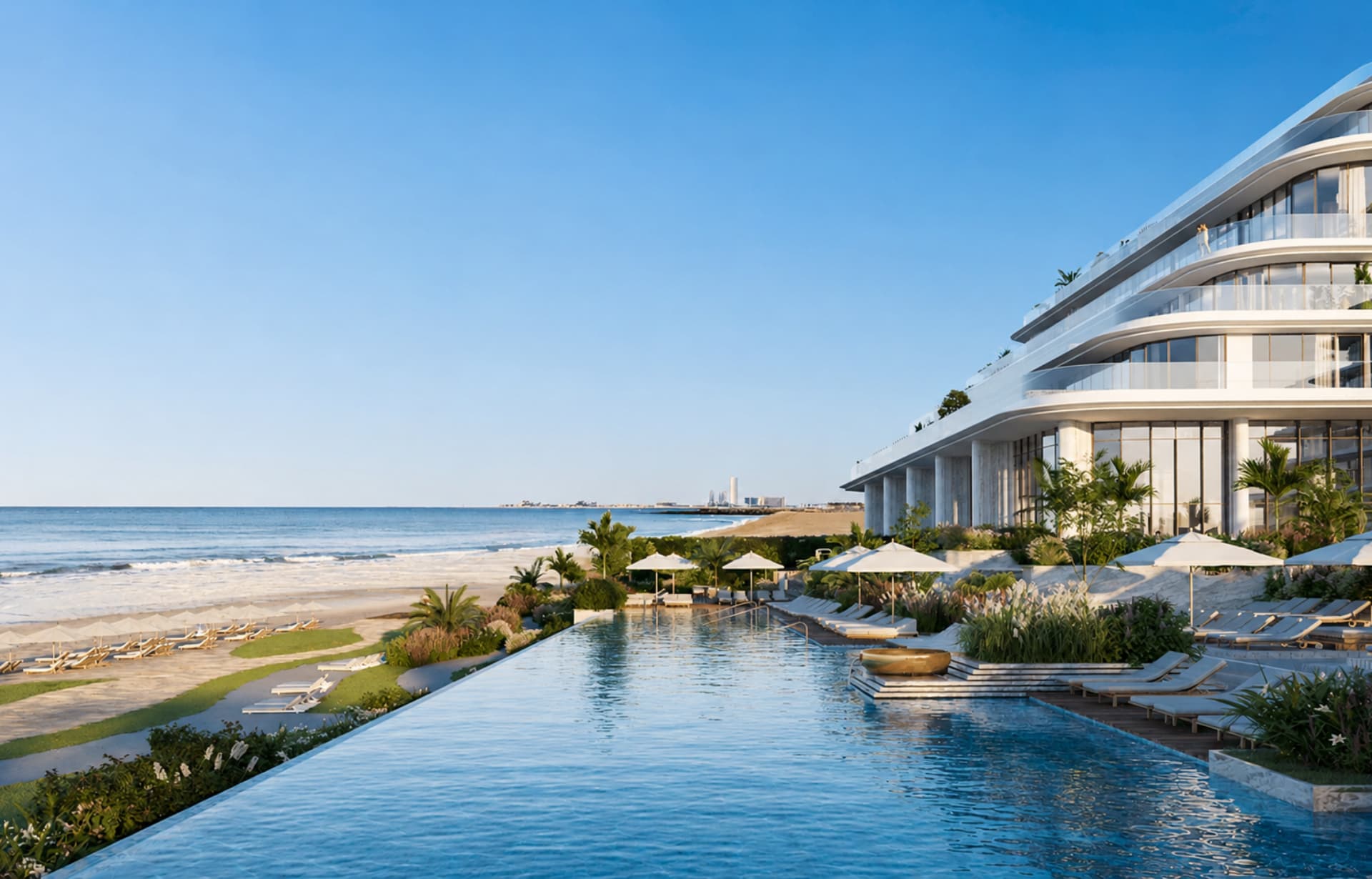 Modern curved white beachfront resort with infinity pool overlooking sandy beach and ocean