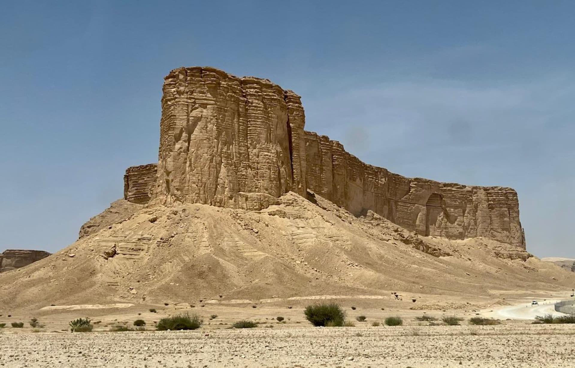 Ancient stone mountain fortress ruins in desert landscape with clear blue sky