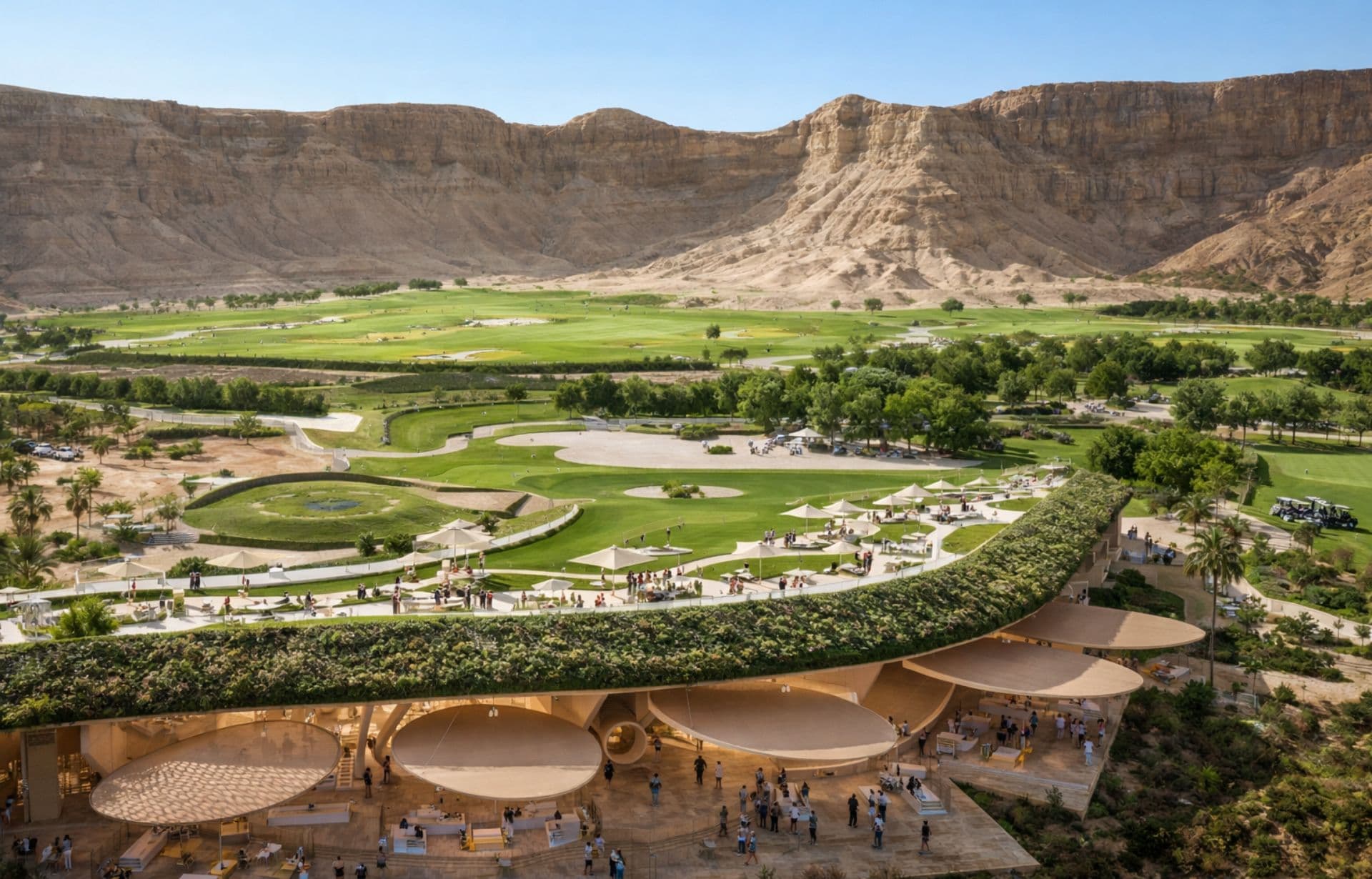 Modern architecture with curved roof domes overlooking green valley and dramatic desert mountains