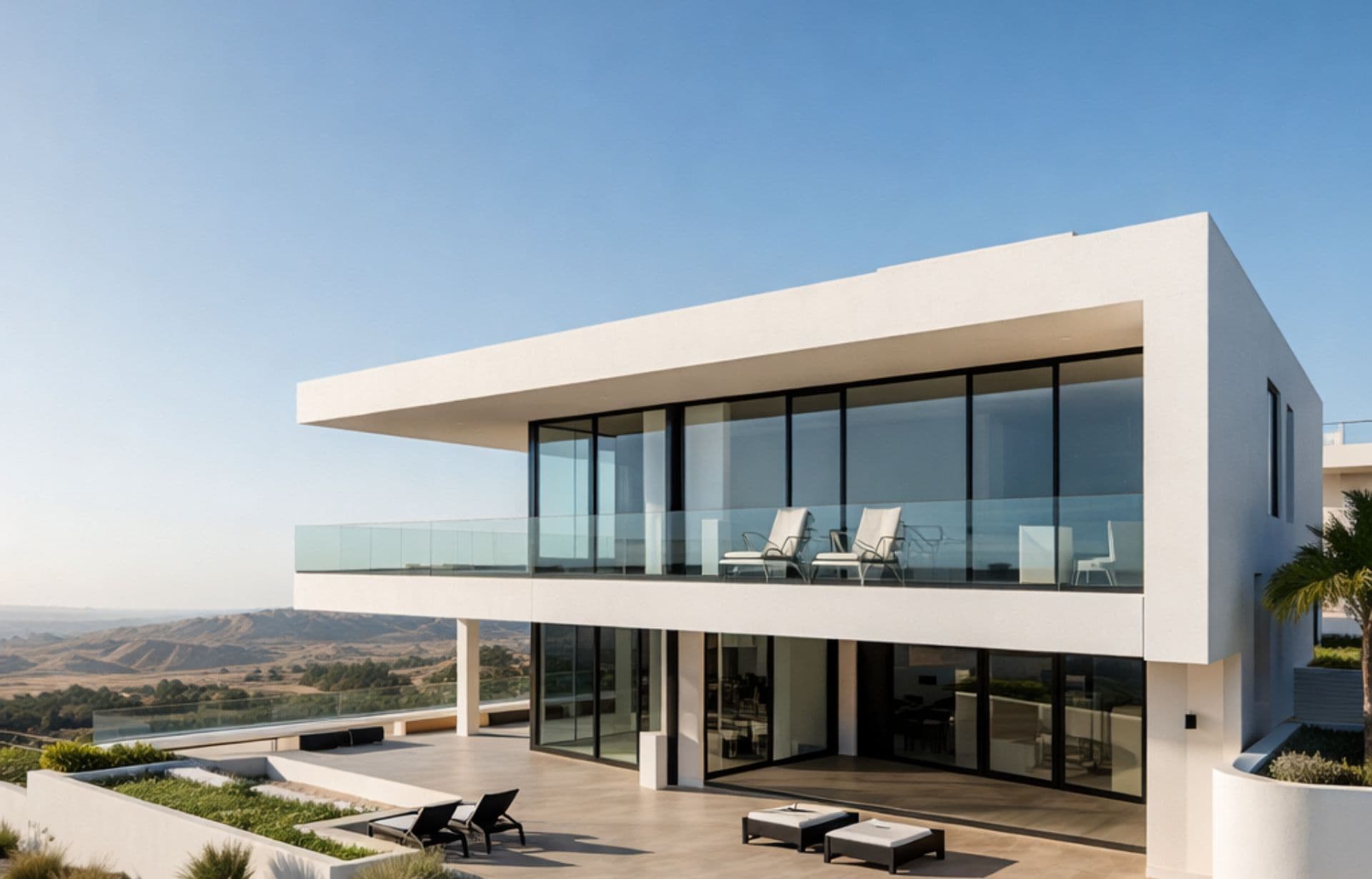 Modern white house with large windows overlooking scenic valley and river landscape