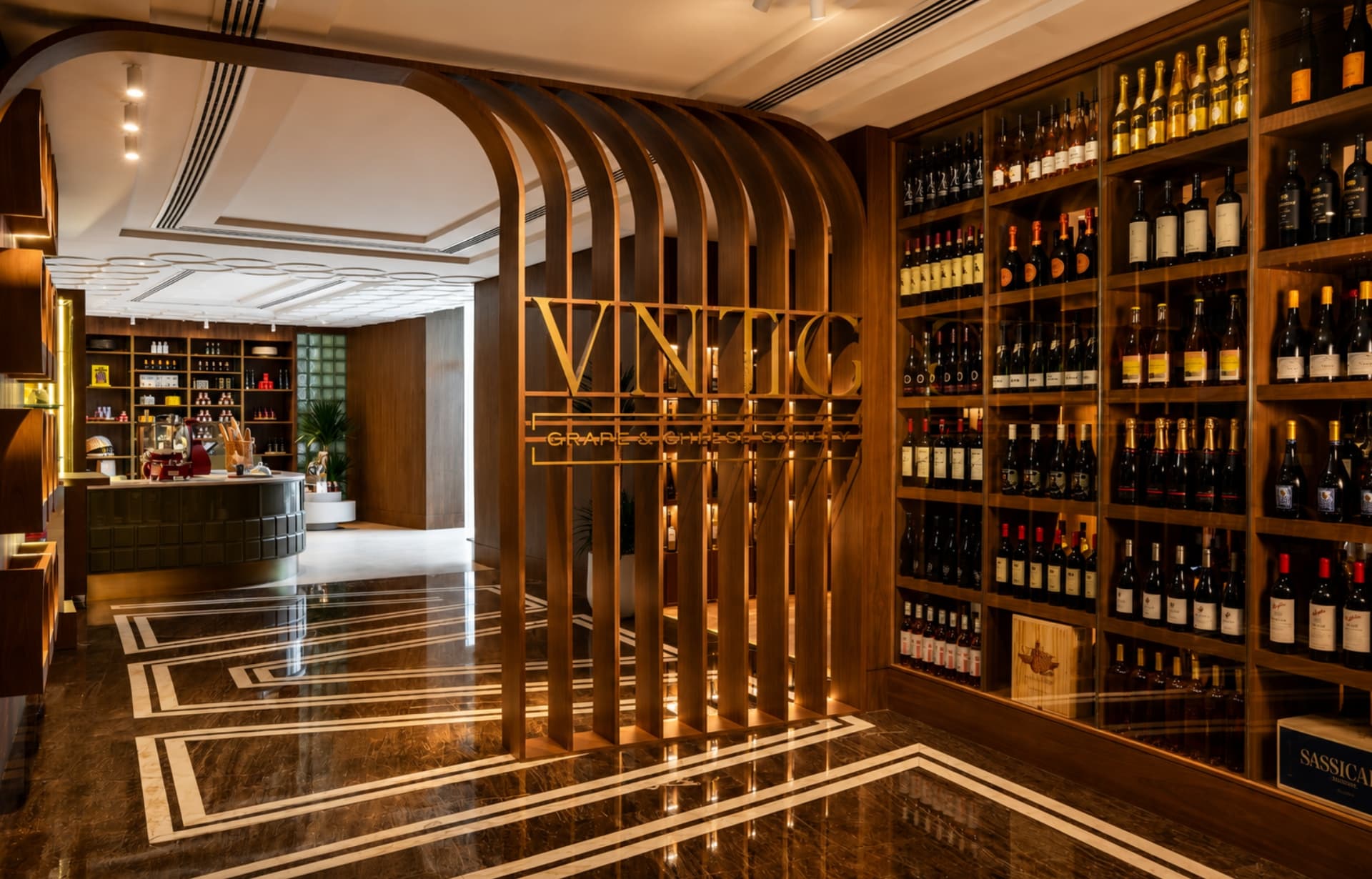 Luxury wine cellar with wooden shelving displaying bottles and golden VINO signage.