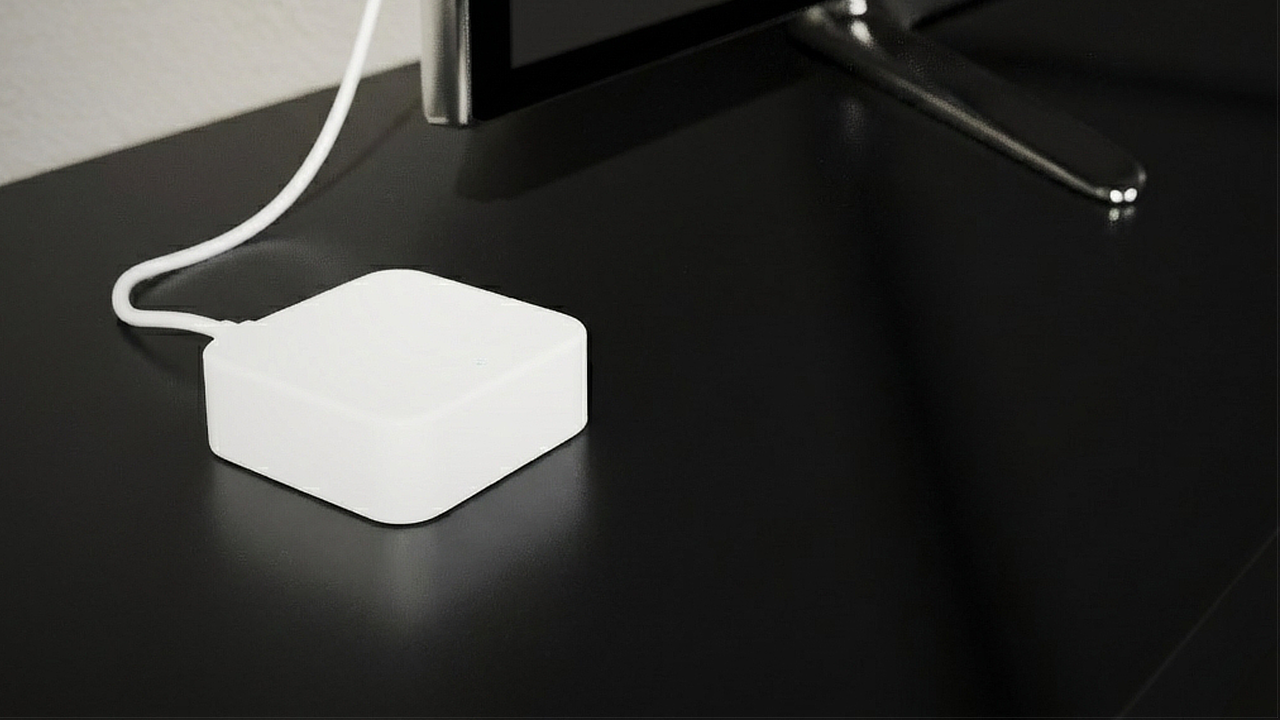 The BLACK X Wi-Fi Bridge, a small white device connected by a USB-C cable, placed on a black media console beside a TV.