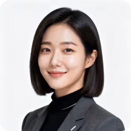 Portrait of a woman with straight shoulder-length black hair wearing a gray blazer and black turtleneck, smiling slightly against a light background.