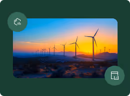 Wind turbines at sunset with a colorful sky and desert landscape.