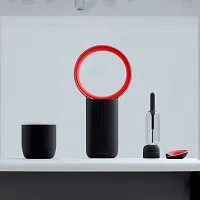 Modern black and red bladeless fan and accessories arranged on a white surface.