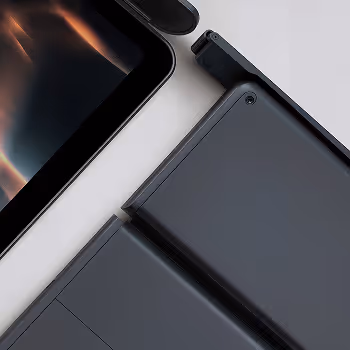 Close-up of sleek black tablet and detachable keyboard on a white surface.