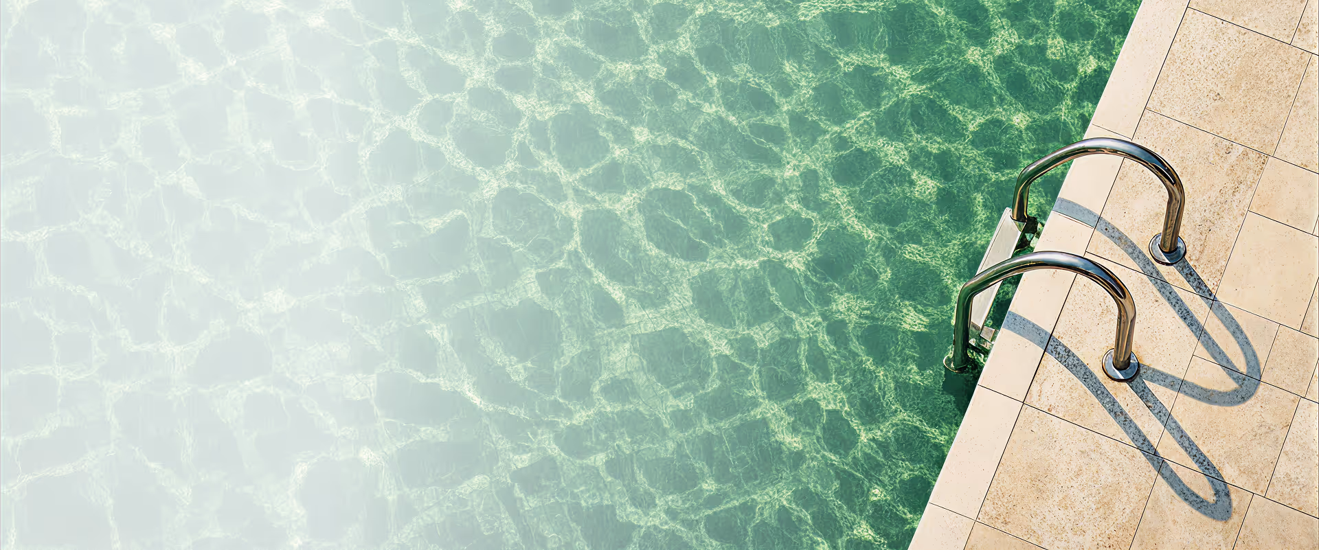 Vue aérienne d'une échelle en métal à côté d'une piscine aux eaux claires.