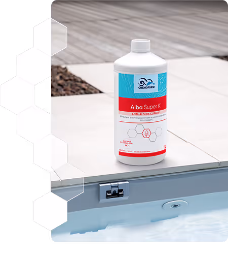 Bouteille de produit anti-algues Alba Super K posée au bord d'une piscine avec une margelle en carrelage.