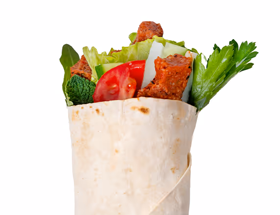 Wrap gefüllt mit veganen Köfte, Tomatenscheiben, Salat und frischen grünen Kräutern.