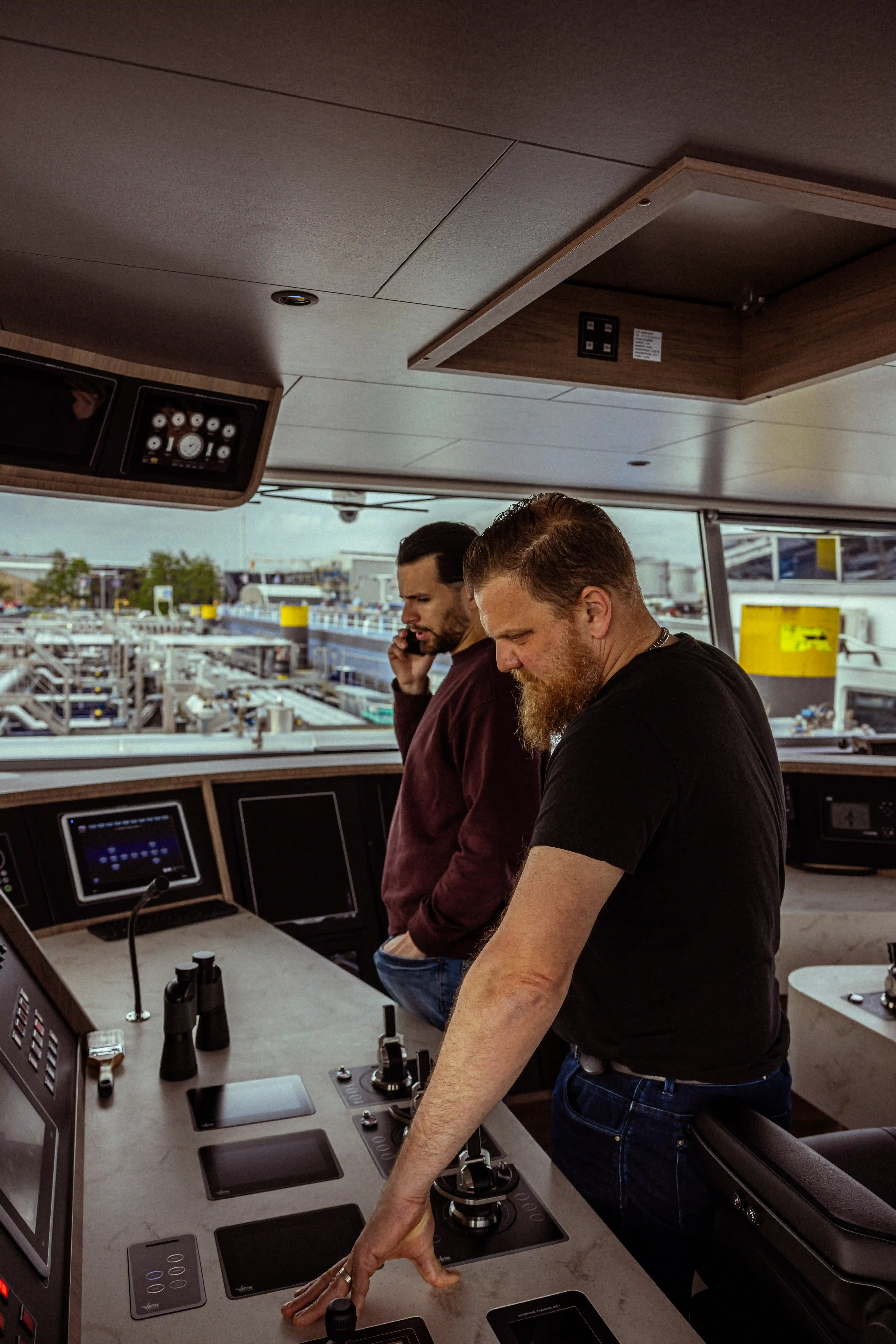 Twee kapiteins of stuurlieden van Mercurius in een lichte, moderne stuurhut tijdens de navigatie en communicatie aan boord