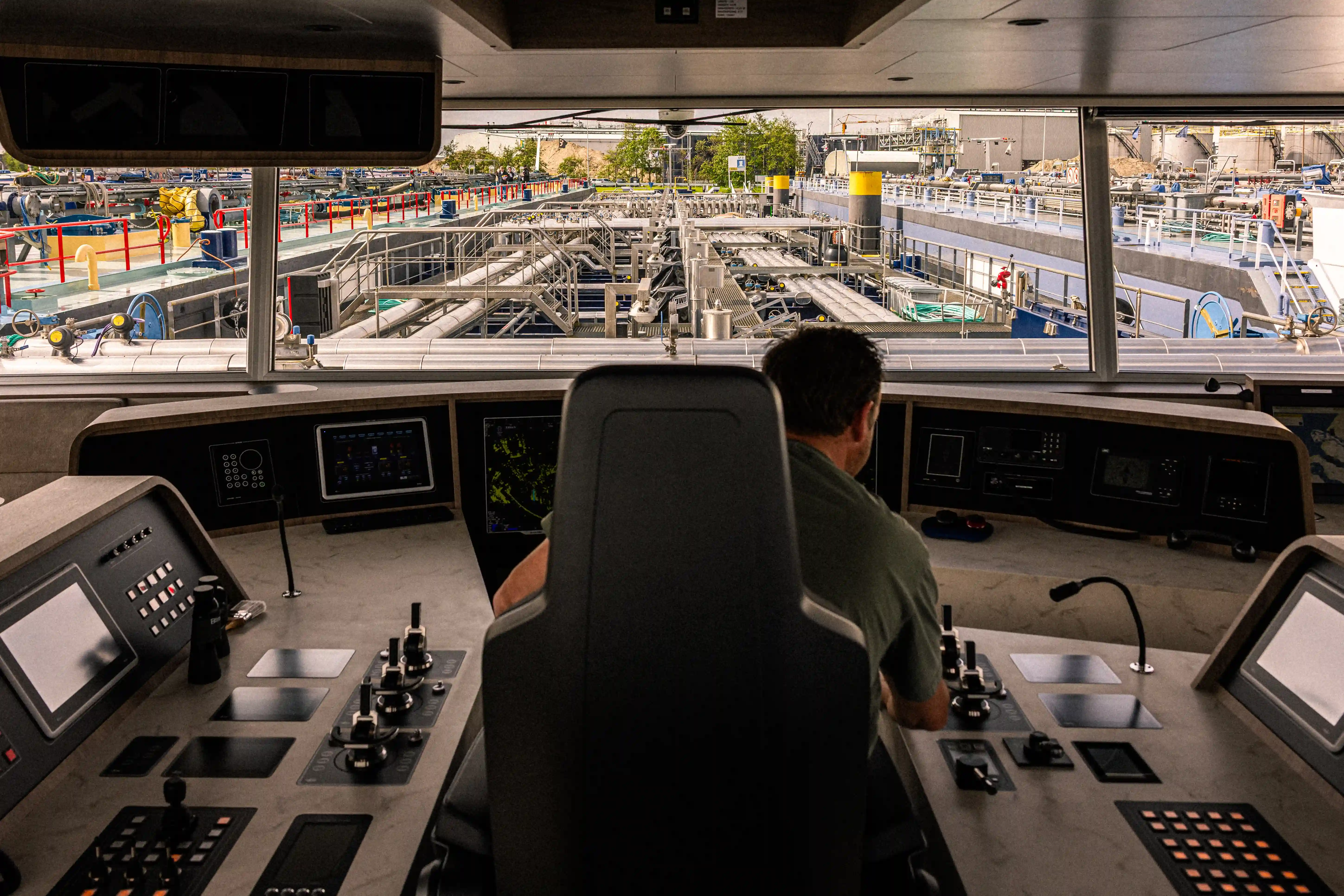 Zicht vanuit de stuurhut van een binnenschip waarbij de stuurman uitkijkt over het voordek