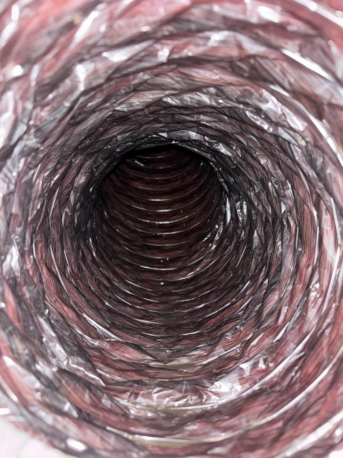 Inside view of a flexible black ventilation duct with metal duct and blade visible at the end.