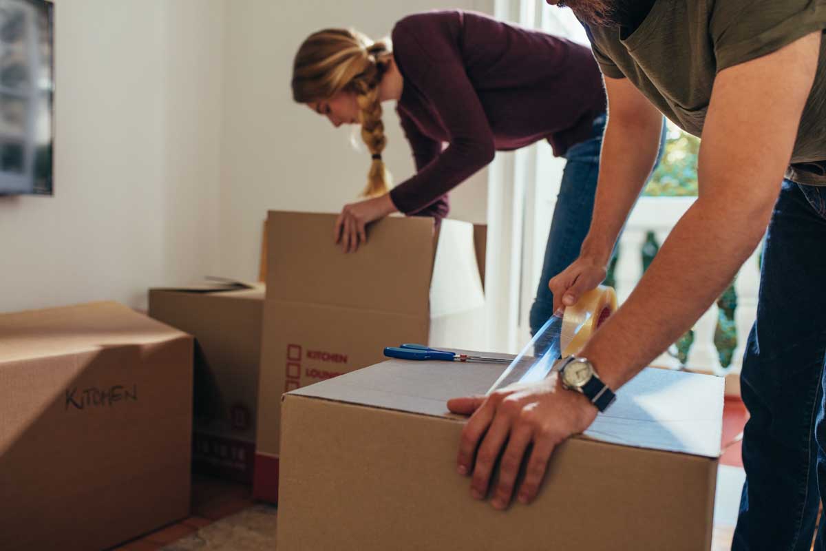 Image depicting couple packing to move