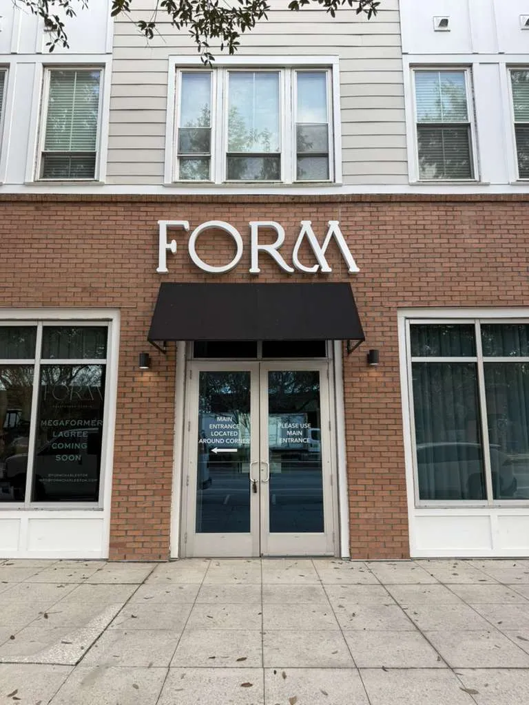 Brick storefront with large white FORM sign and glass double doors with a black awning above.