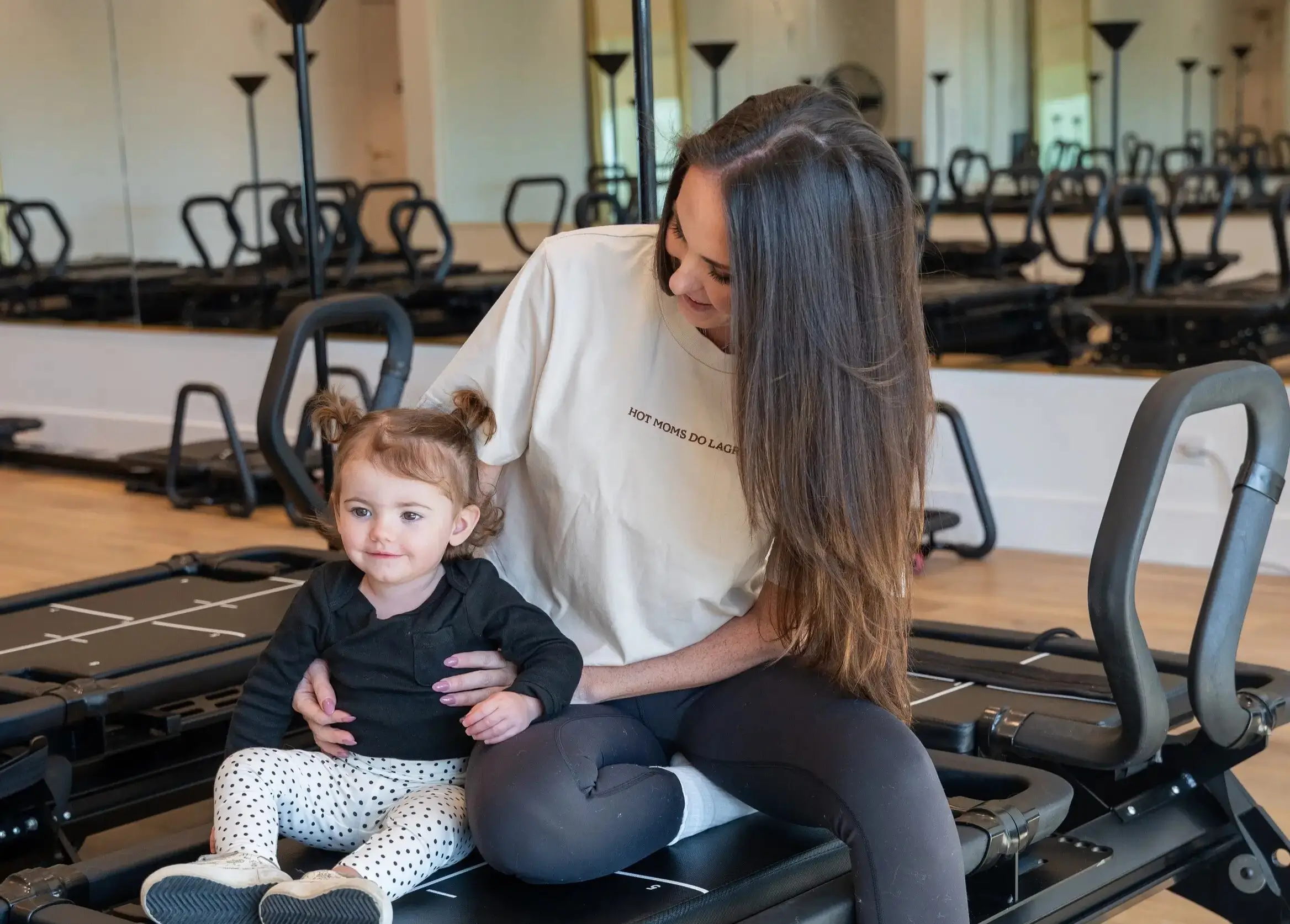 FORM Charleston instructor with a toddler on the Megaformer at the Mount Pleasant studio