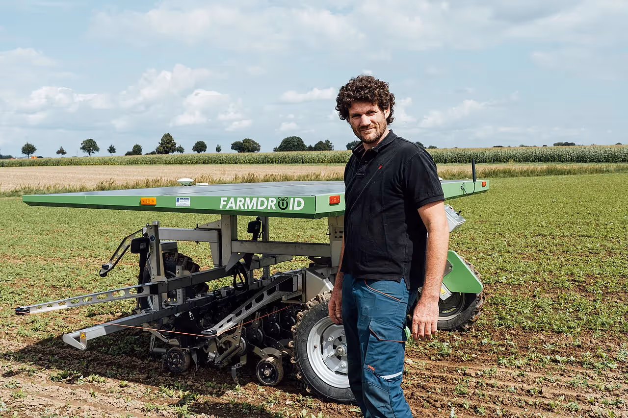 Agrarroboter und Mann auf einem Feld 