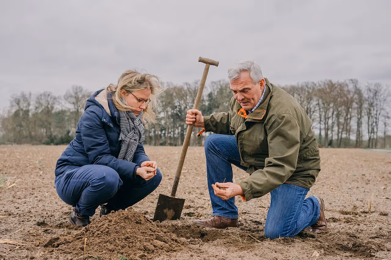 Zwei Menschen, die auf dem Feld hocken