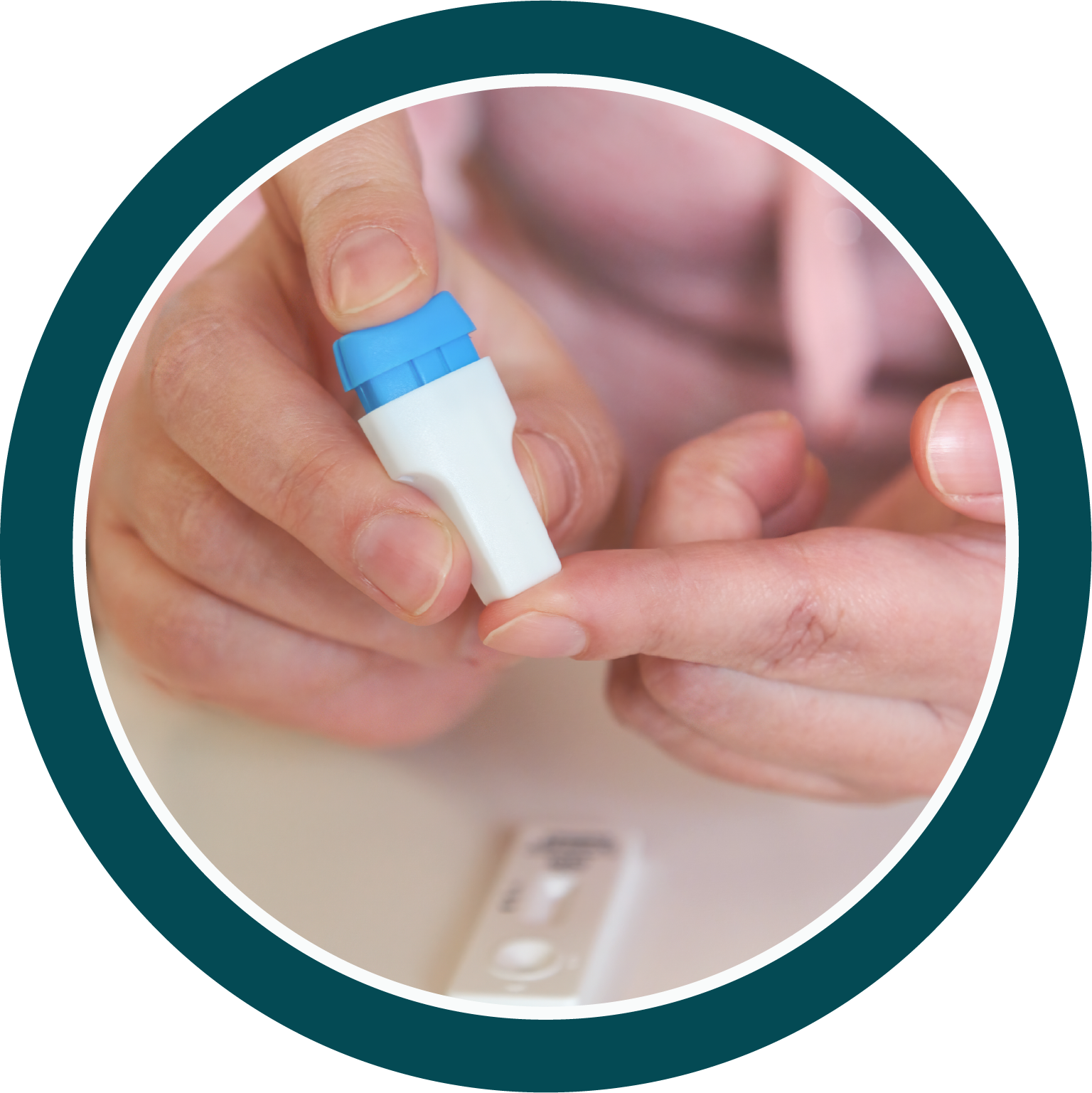 Person using a lancet device to prick their finger for a blood test with a test cassette on the table.
