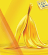 Yellow banana peel standing upright on a yellow surface with an abstract yellow background.