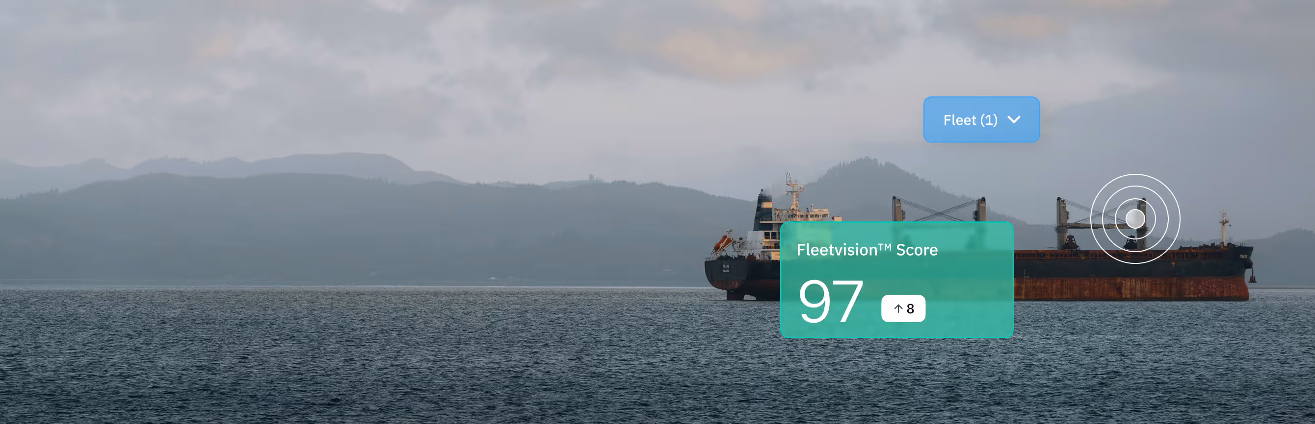 Cargo ship sailing on calm water with misty mountains in the background and a digital overlay showing a Fleetvision score of 97.