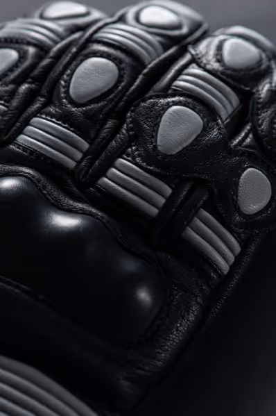 Close-up of a black protective glove with gray padded armor on the knuckles and fingers.