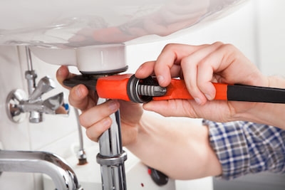 person fixing drain on sink