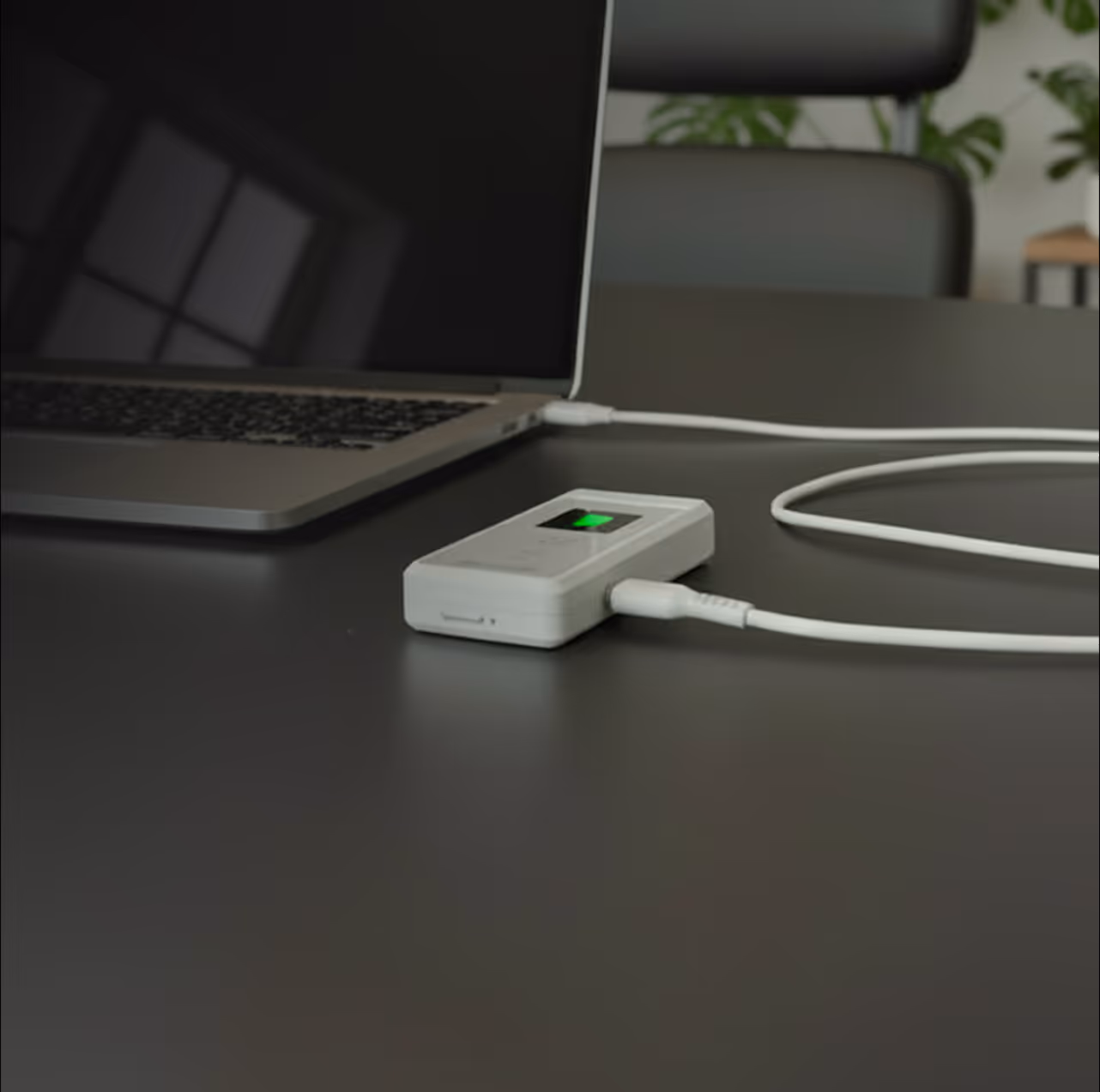 A white Minilab IQ breathalyzer connected to a laptop via a USB-C cable. Text highlights a rechargeable lithium battery lasting up to one month and an automatic power-off feature.