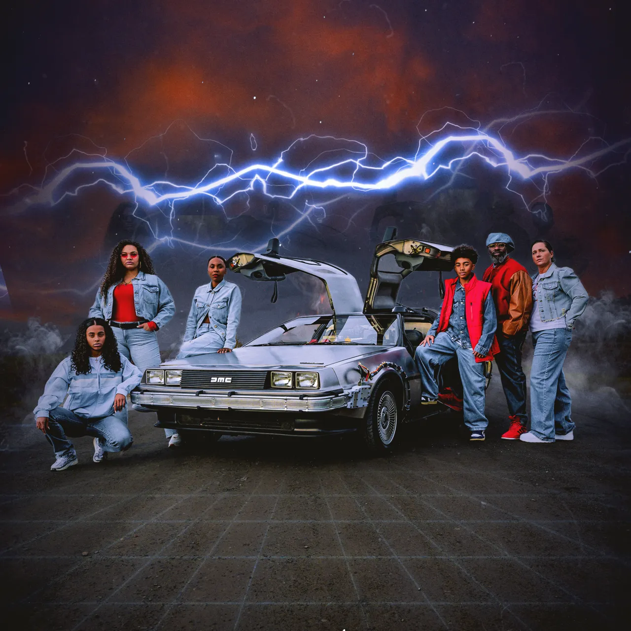 Six people posing around a silver DeLorean car with gull-wing doors open and blue lightning in the dark sky behind.