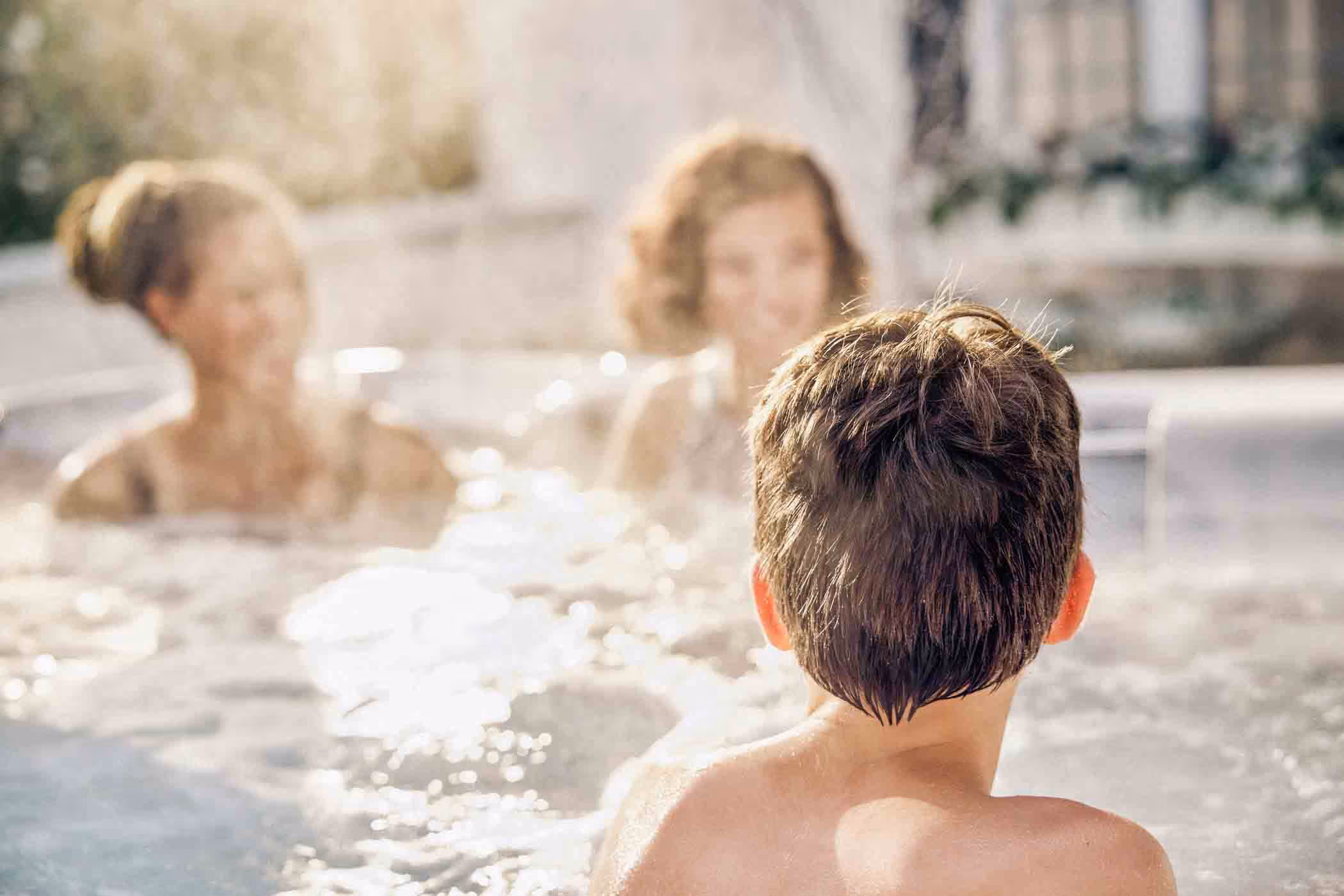 Family in backyard hot tub