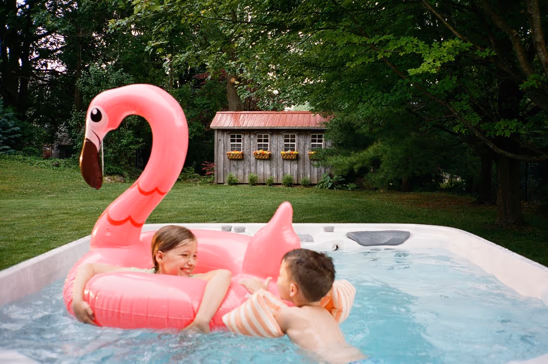 kids playing with a flamingo in a swim spa