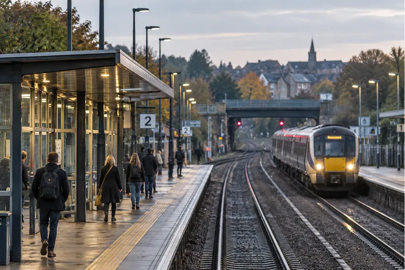 Passengers on a railway station platform as a train arrives