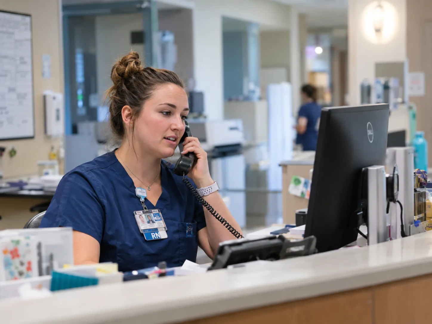 Nurse taking a phone call at a hospital reception desk