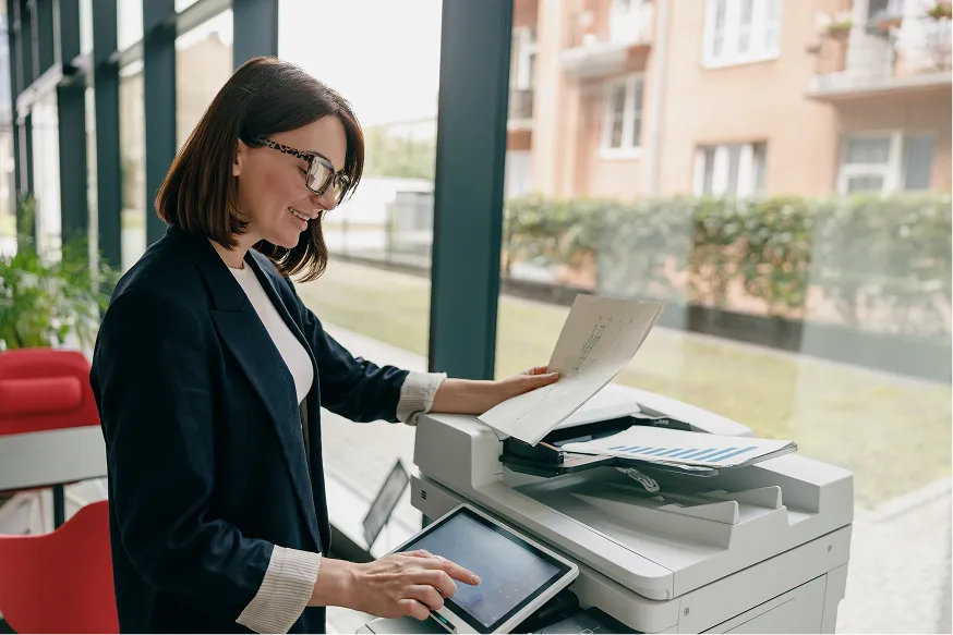 Woman using the touchscreen on an office printer
