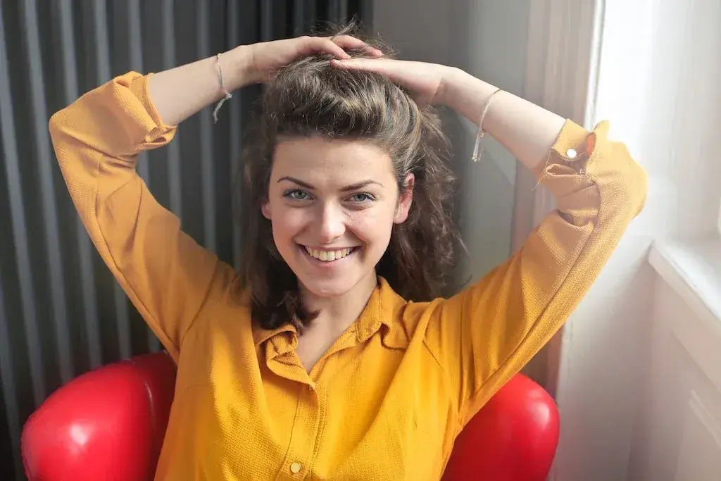 a young woman sitting, smiling after being recognized at work