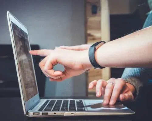 fingers pointing to laptop screen