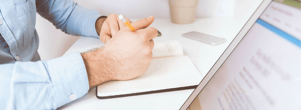 hands writing in notebook