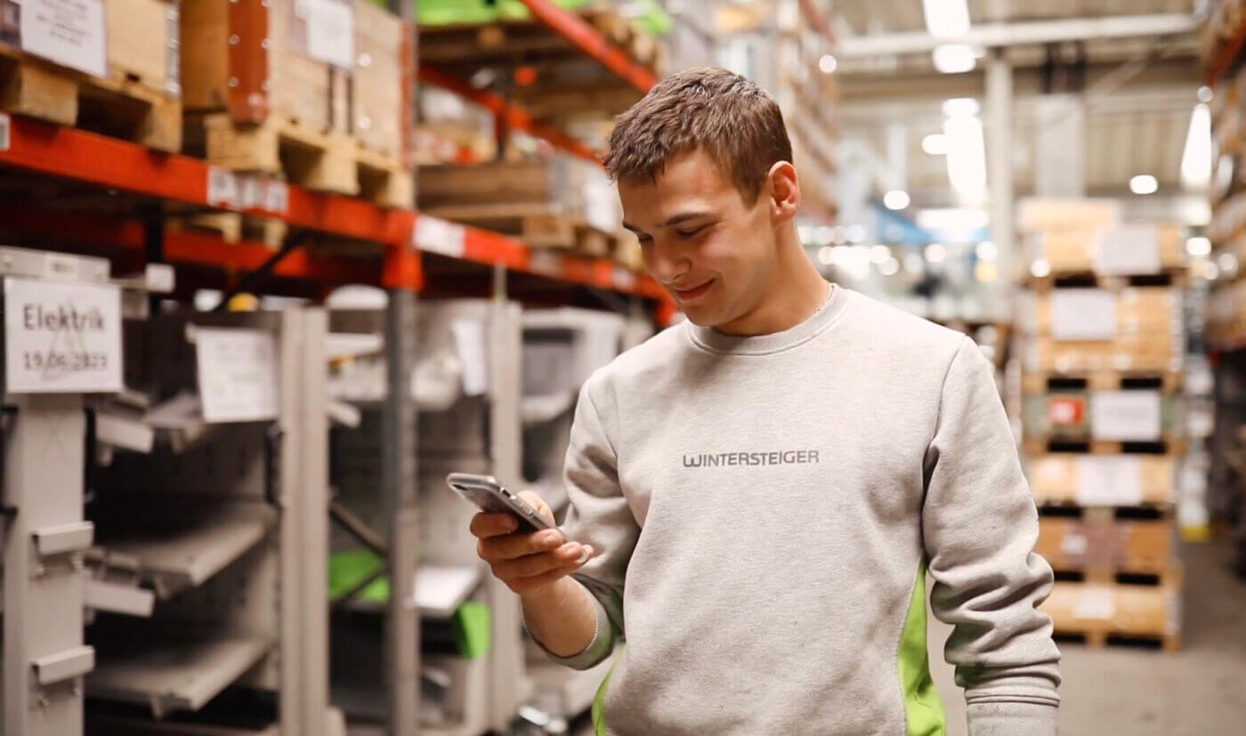 Mitarbeiter von Wintersteiger schaut auf Handy