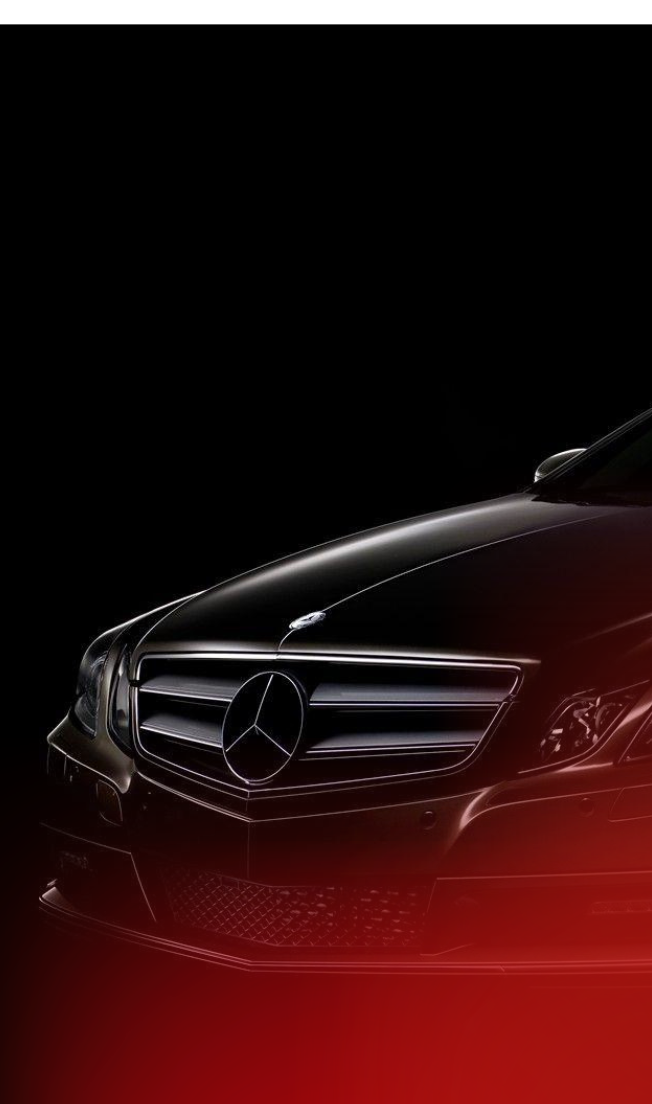 Close-up view of the front grille and emblem of a black Mercedes-Benz car with dark background.