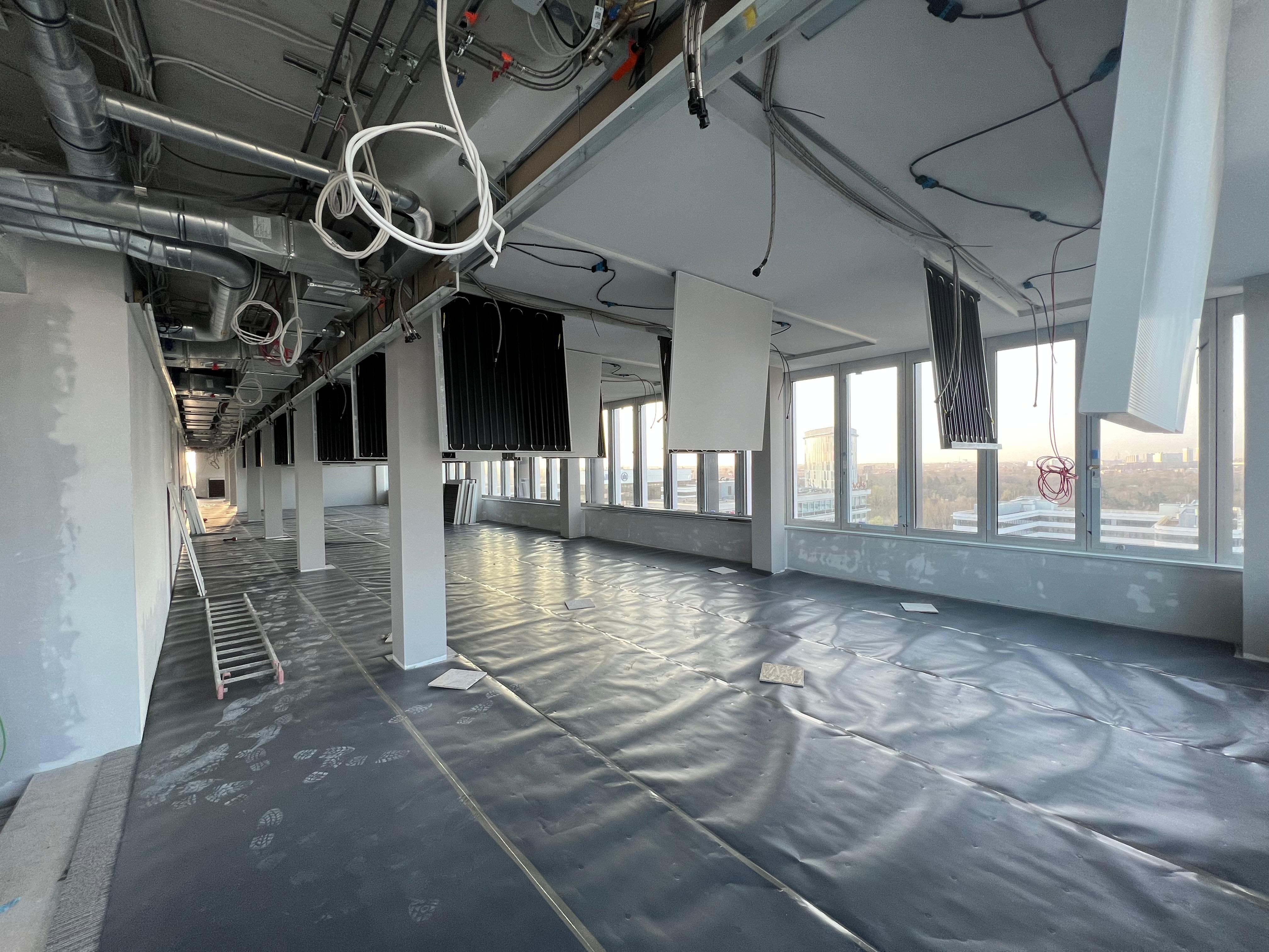 Offene Bürofläche mit montierten Deckensegeln und sichtbarer Haustechnik