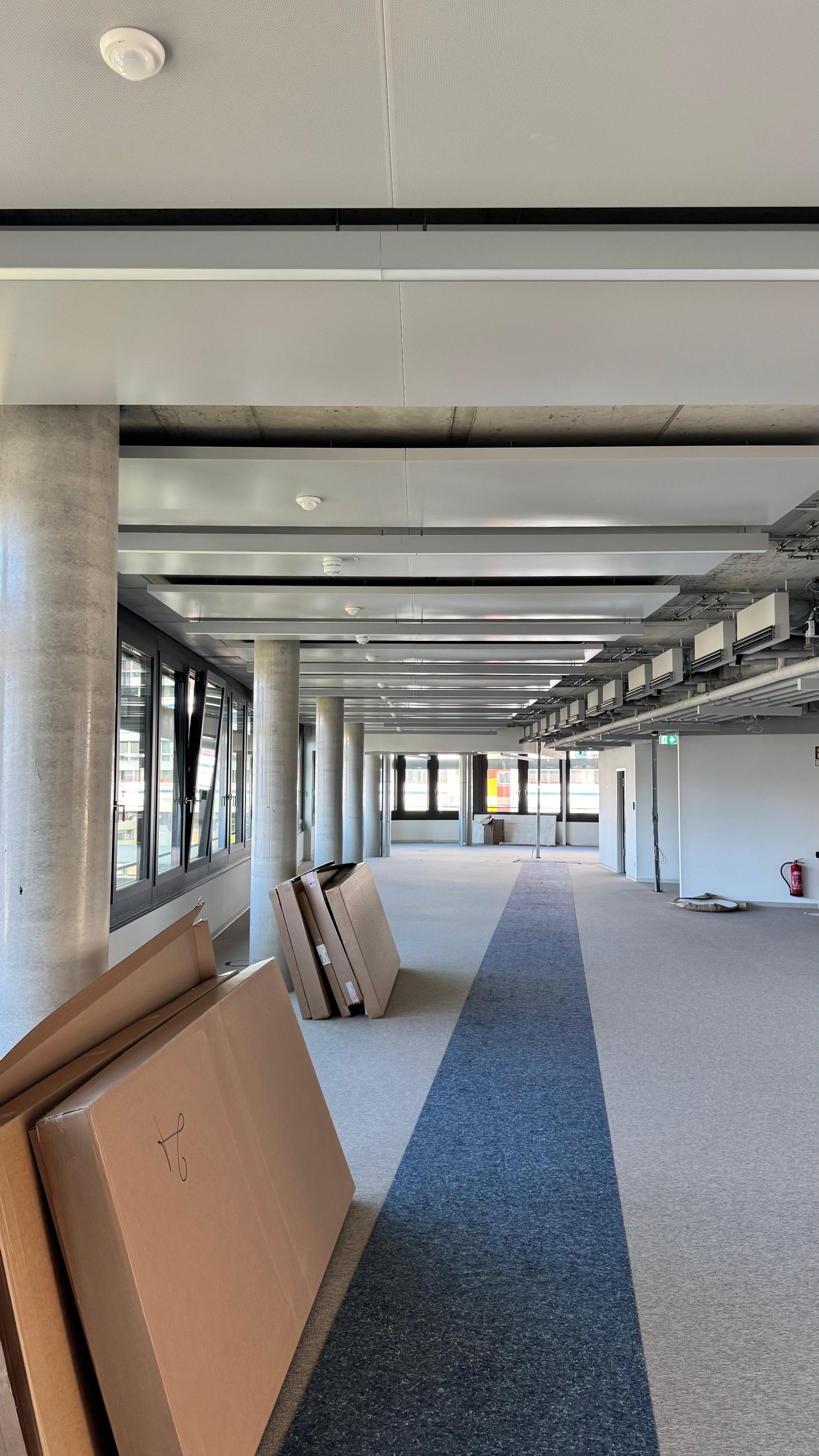 Offene Bürofläche in Ausbauphase mit montierten Deckensegeln und sichtbarer Haustechnik.