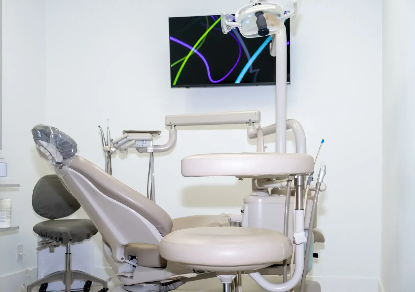 A dental chair and equipment are set up in a clean, modern dentist's office.