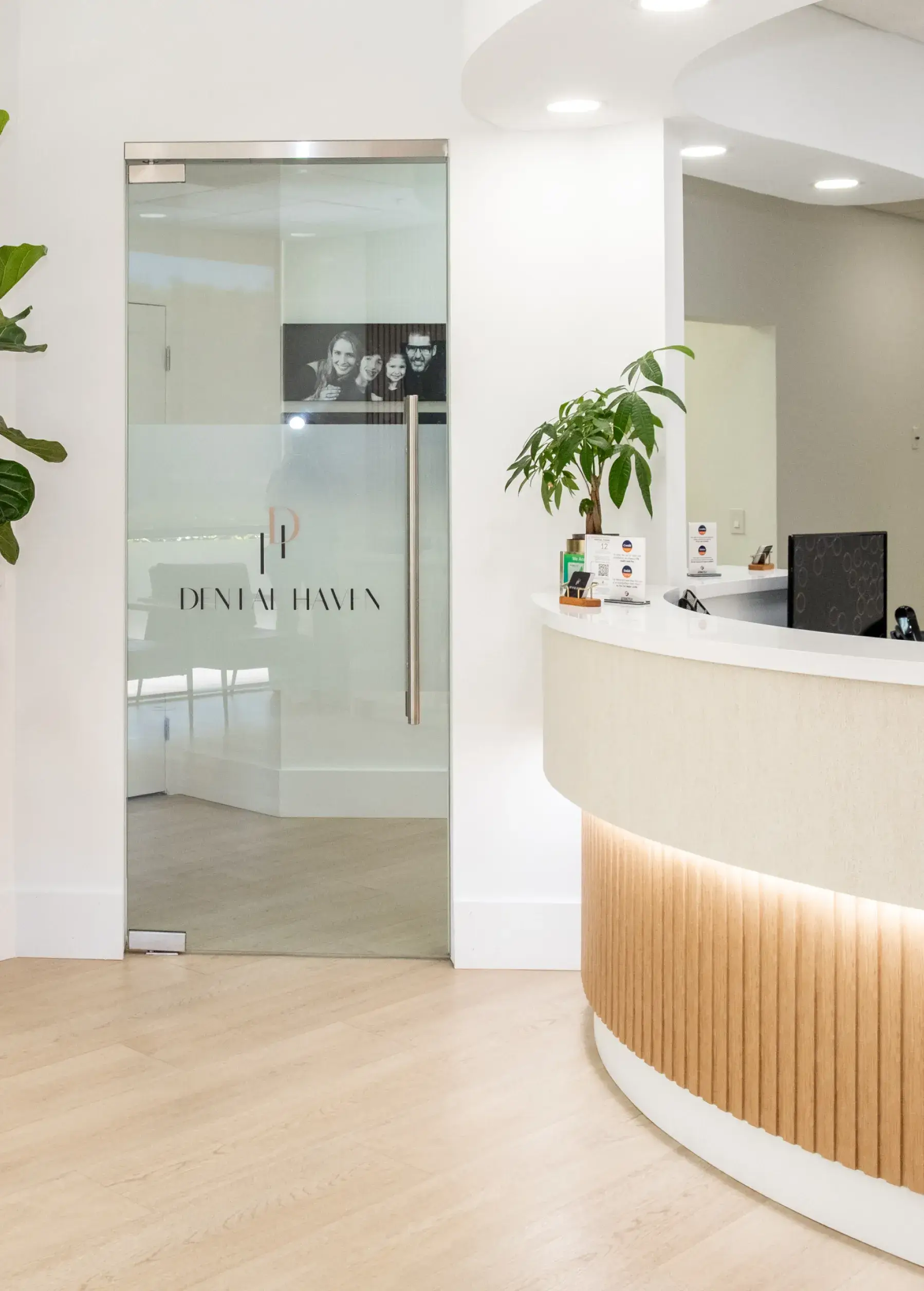 Reception area with a curved desk and glass door labeled "Dental Haven."