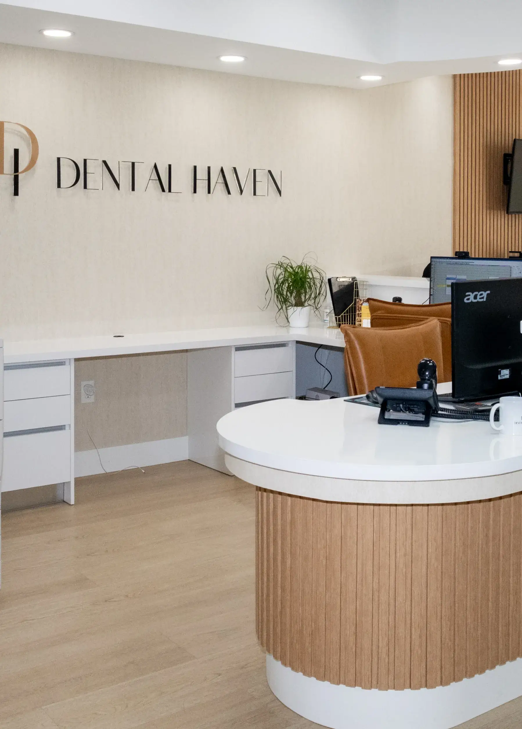 Reception area of Dental Haven with a curved desk, computer, and chair.