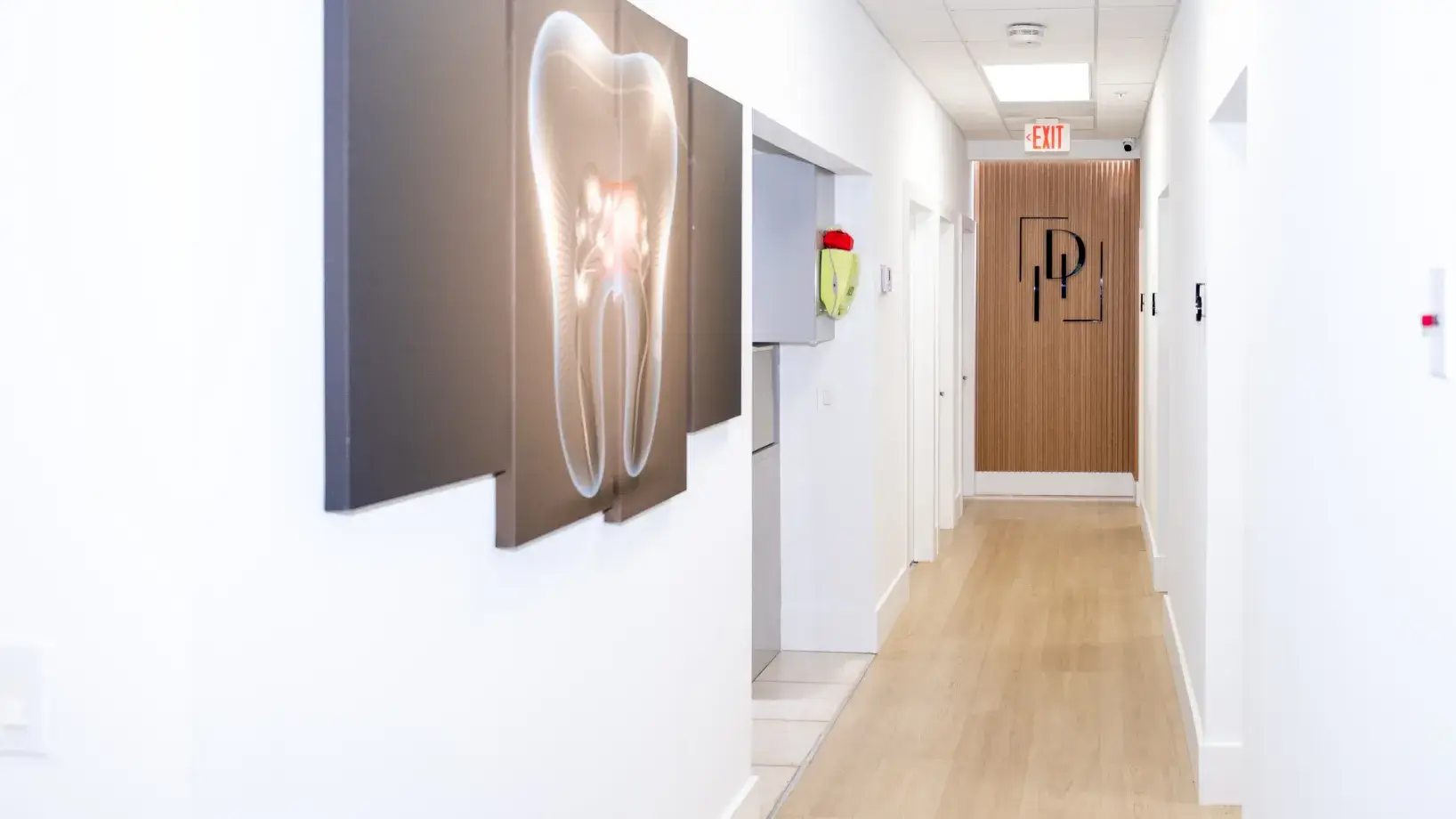 Hallway in a dental office with a large tooth image on the wall.
