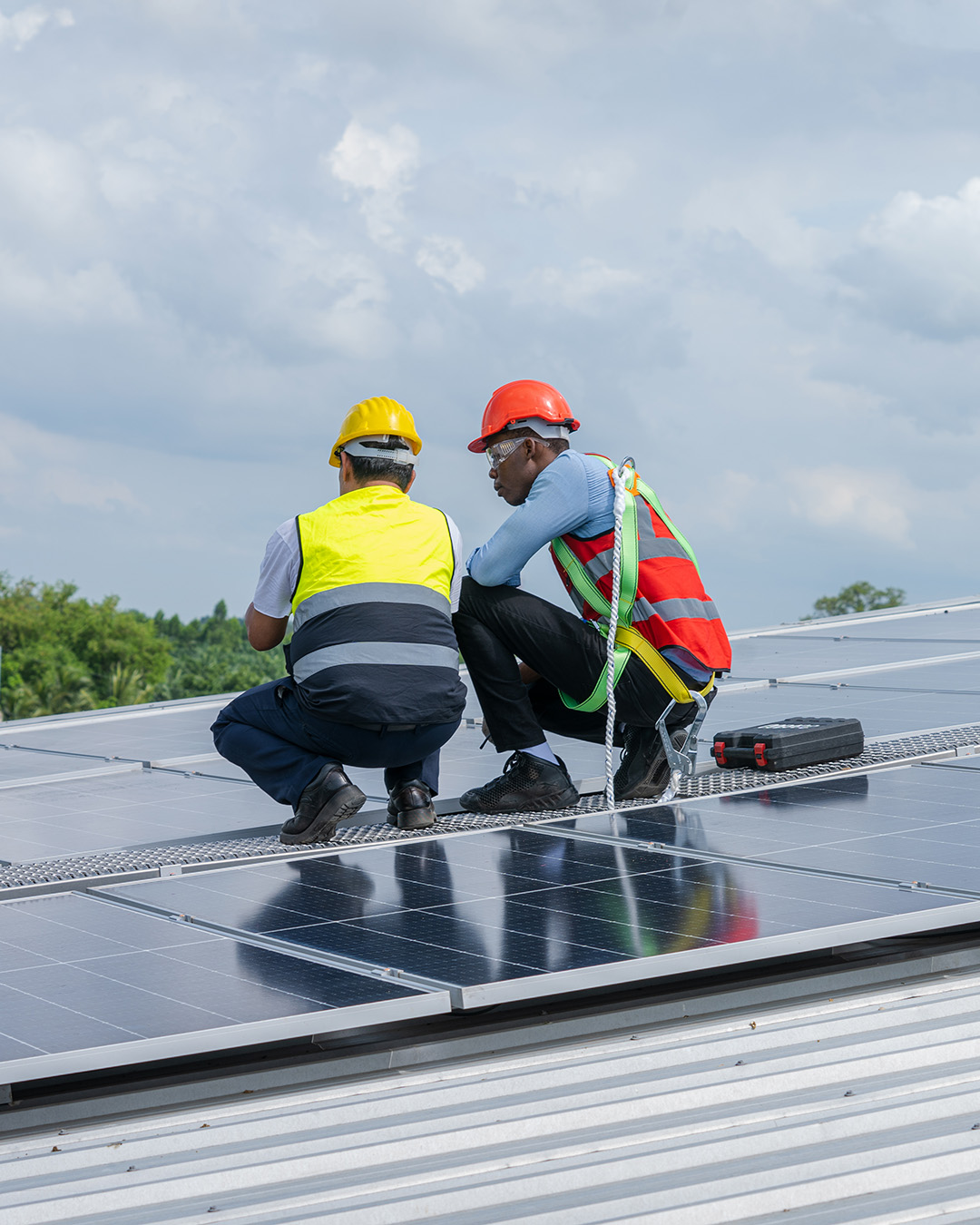A photo of two roofing professionals assessing a solar panel installation