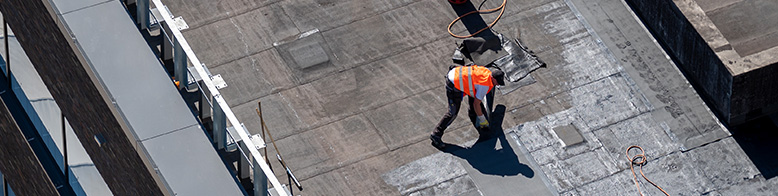 An aerial photo of professional roofers re-roofing a commecial building