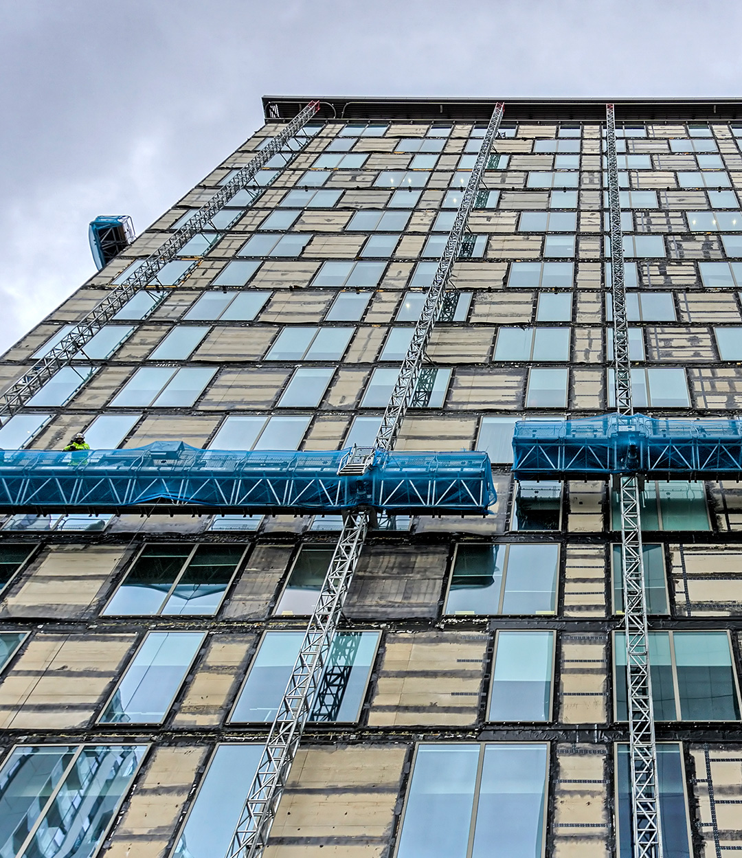 an exterior view of scaffolding surrounding a glass and steel office building