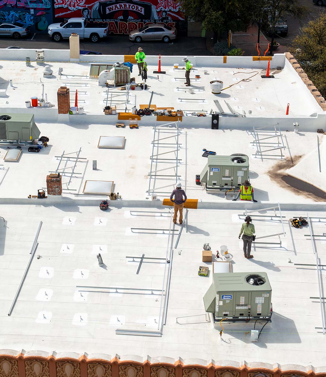 Roofing professionals working on a new industrial rooftop in an urban neighbourhood
